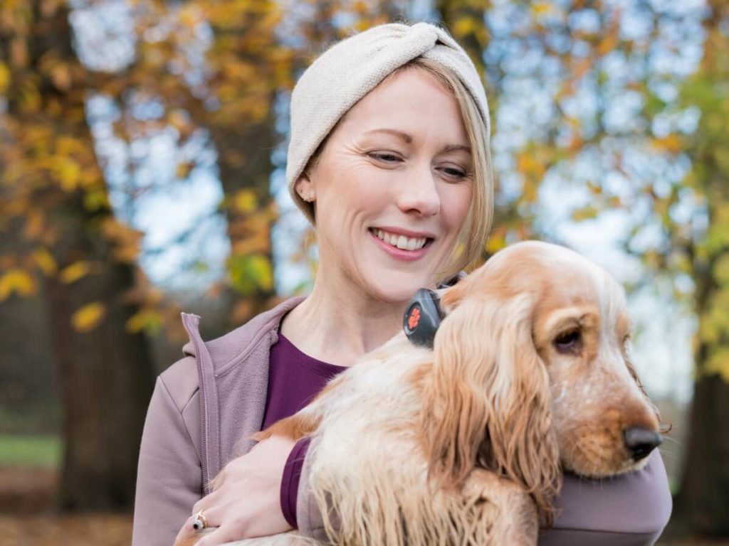 woman holding cocker spaniel wearing a PitPat